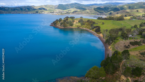 Aerial View of Waitawa Regional Park, Beach, Pier, Deck Green Trees and Cliff in New Zealand - Auckland Area