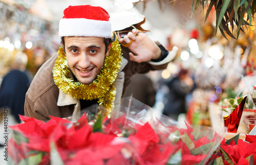 Portrait of happy young man Christmas hat with looking toys at fair outdoor