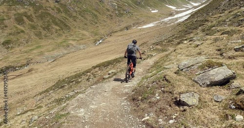 Mountain biking on a single trail with a enduro MTB in high alpine terrain. Follow camera mountain biking  in the austrian alps tirol with friends. Close up MTB riding on rocks and dirth 4K photo