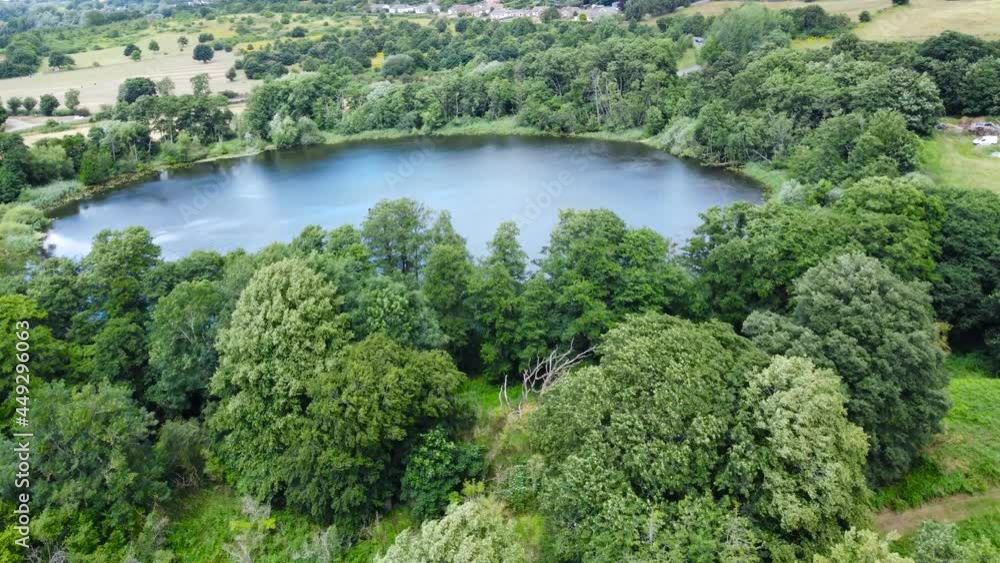 Aerial view of bosmare lake needham market england. Drone fly above the lake with Green Meadows field Aerial view of bosmare lake needham market england. Drone fly above the lake with Green Meadows field