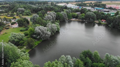 Drone fly around Needham market lake with beautiful view of the little traditional English village during a sunny day of summer. Green natural vegetation photo