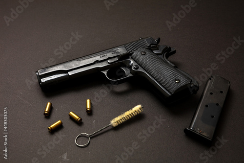 Pistol gun 9mm and ammunition, on black table. Auto metal weapon side view
