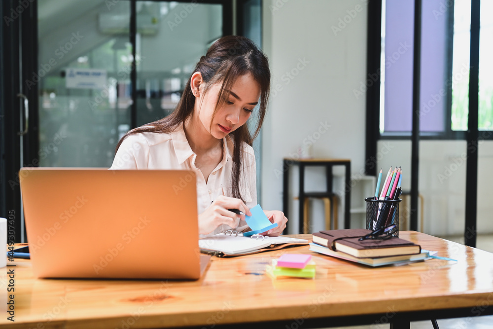 Young Asian woman working with laptop computer in office. Young Asian woman working with laptop computer in office.