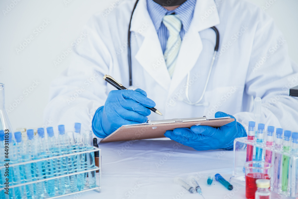medical or scientific researcher researching and experimenting Multi-colored solution, vial and microscope In the laboratory or in the laboratory by wearing blue gloves and white clothing completely. medical or scientific researcher researching and experimenting Multi-colored solution, vial and microscope In the laboratory or in the laboratory by wearing blue gloves and white clothing completely.
