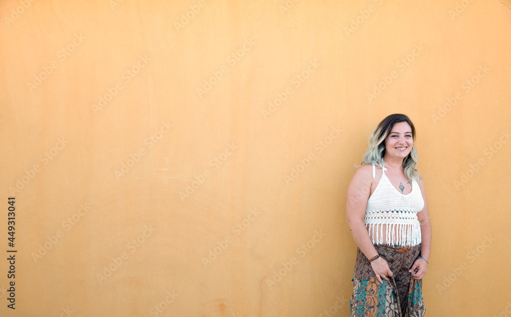 Fototapeta premium Portrait of Happy Spanish girl against yellow wall