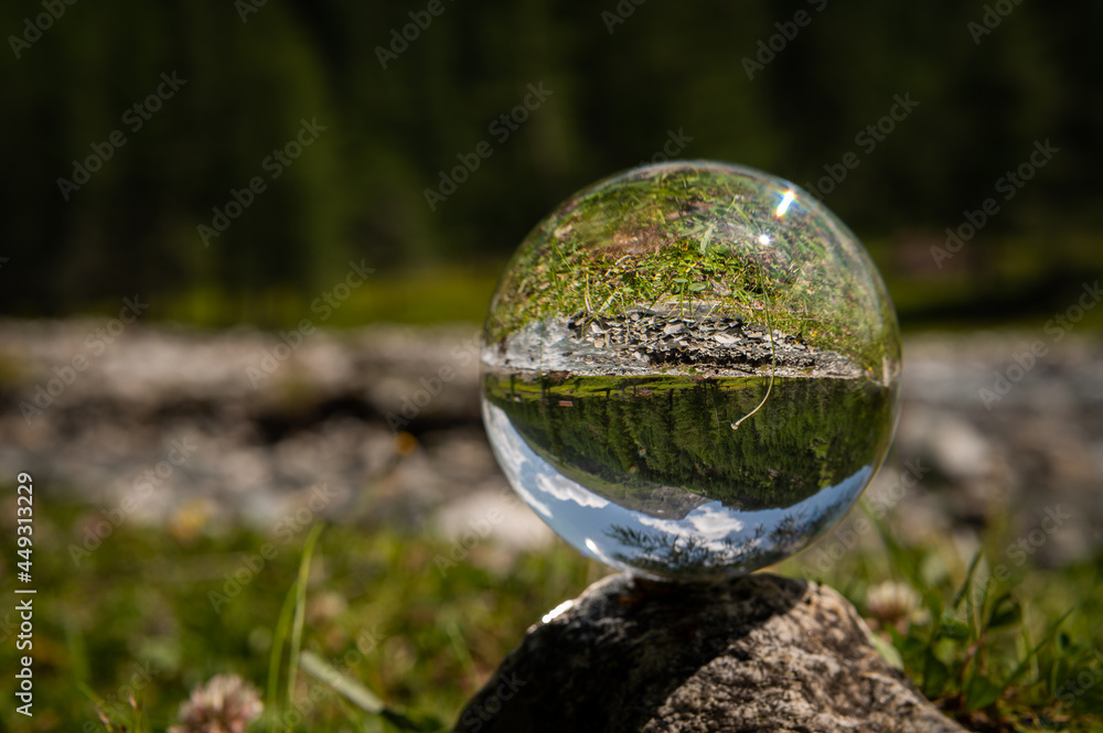 Glass sphere lying on a rock, river in Austrian alps Glass sphere lying on a rock, river in Austrian alps