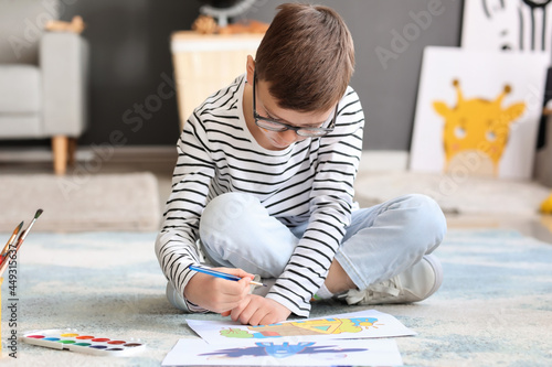 Cute little boy painting at...