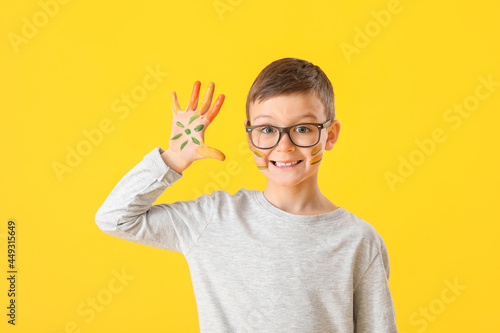 Cute little boy in paint on color background