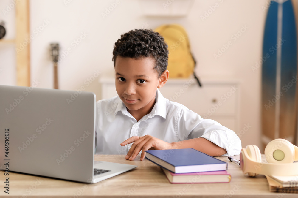 Little African-American schoolboy studying online at home Little African-American schoolboy studying online at home