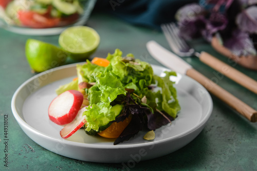 Plate with tasty fresh salad on color background, closeup