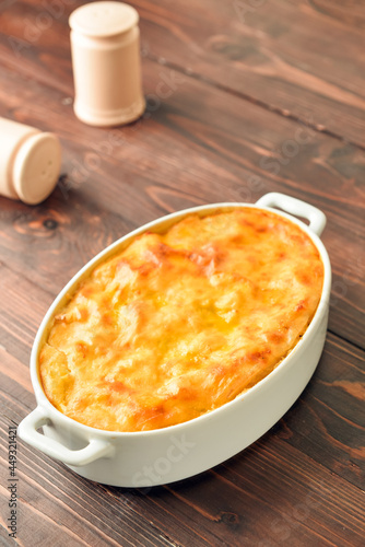 Casserole with mashed potatoes on wooden background
