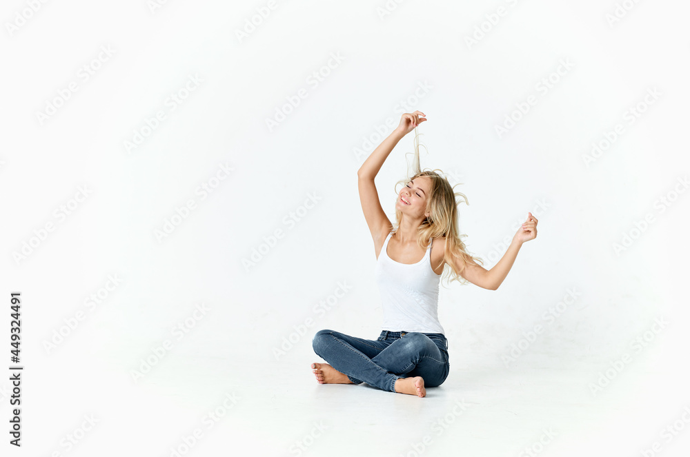 cheerful blonde sitting on the floor emotions posing light background cheerful blonde sitting on the floor emotions posing light background