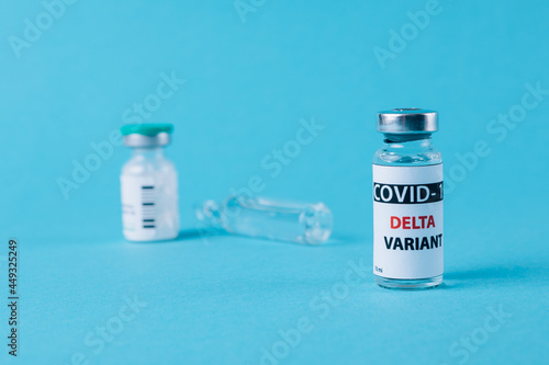 Vaccine bottles covid - 19 delta variant, vials medicine and syringe injection isolated on blue. Coronavirus DELTA 2019-ncov.