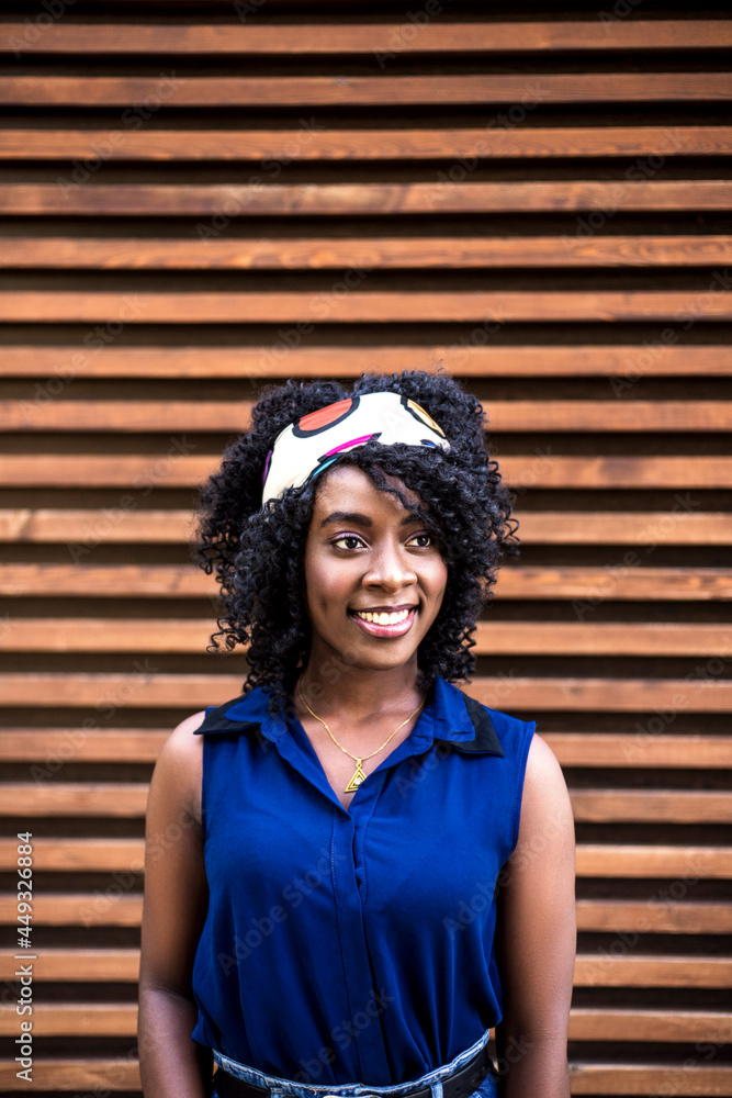 Portrait of a young happy black woman against wooden background. Portrait of a young happy black woman against wooden background.