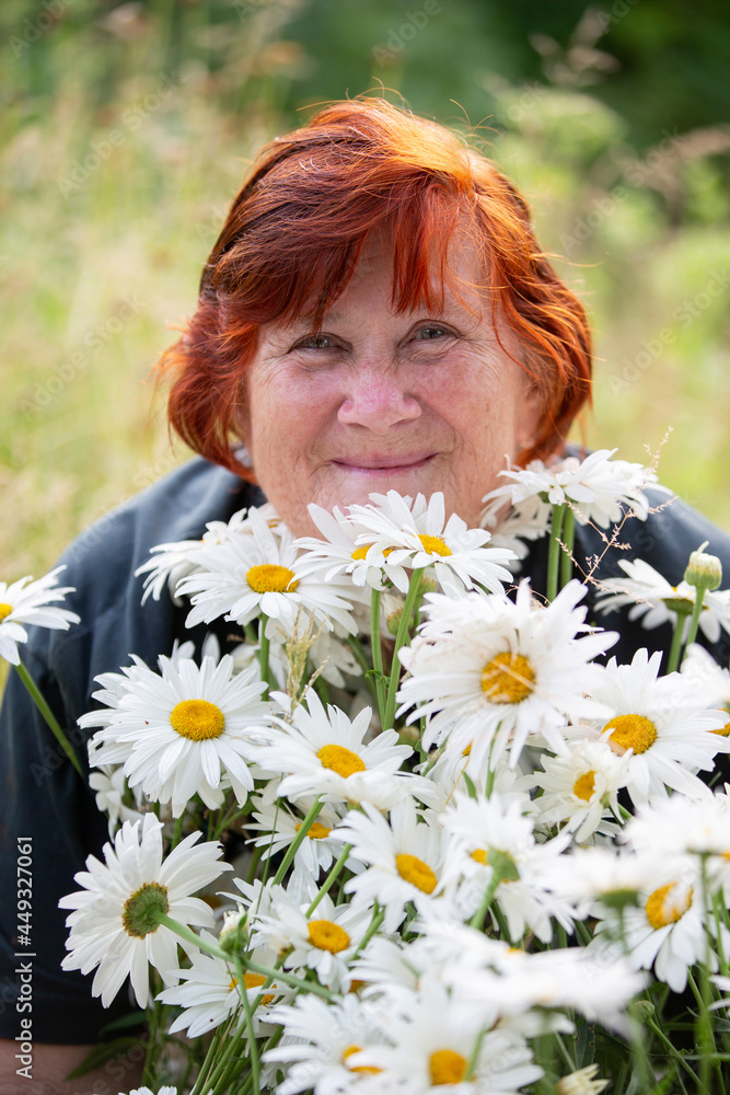 Beautiful elderly woman with a bouquet of daisies smiling and looking at the camera. Beautiful elderly woman with a bouquet of daisies smiling and looking at the camera.