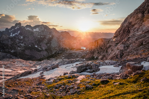 Beautiful landscape at sunset with the sun shining over distant hills in Hoher Dachstein, Austria