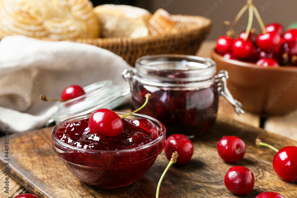 Bowl and jar with tasty cherry jam on wooden background, closeup Bowl and jar with tasty cherry jam on wooden background, closeup