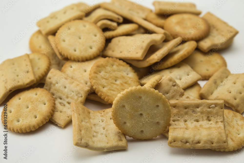 close-up of salty square and round shaped cookies on white background close-up of salty square and round shaped cookies on white background
