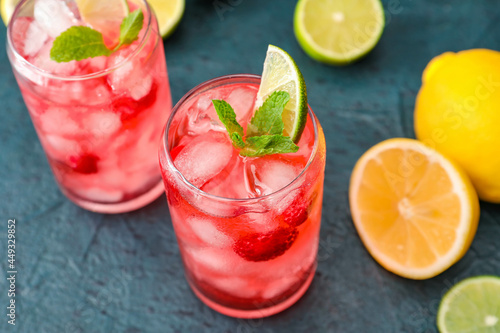 Glasses of delicious raspberry lemonade on color background