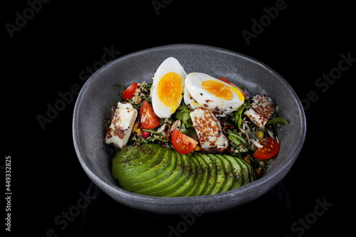 Tuna salad with poached egg on black background