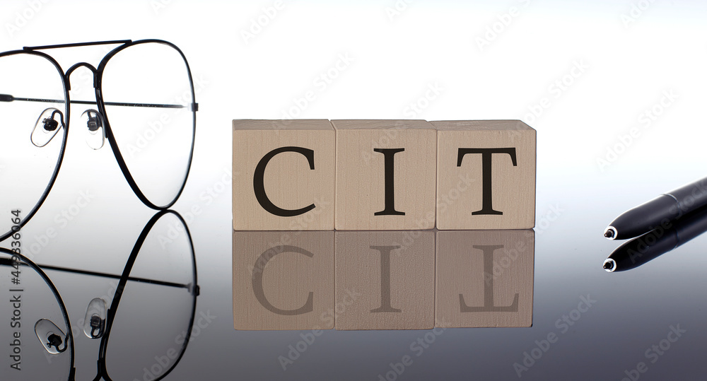 Close-up Of CIT Wooden Blocks on the black background with glasses and pen - obrazy, fototapety, plakaty 