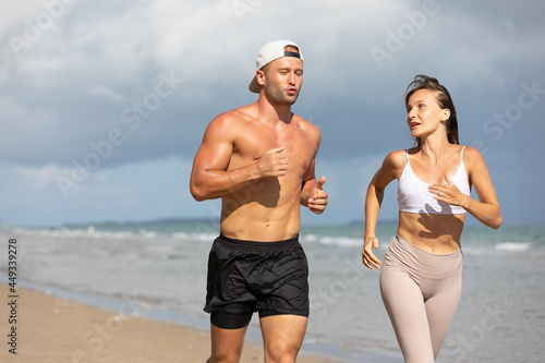 athletics couple running and jogging together on beach