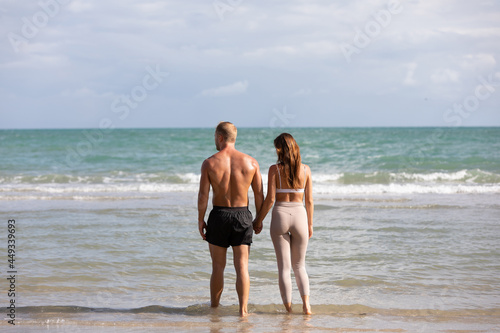 back view couple standing and walking on the beach