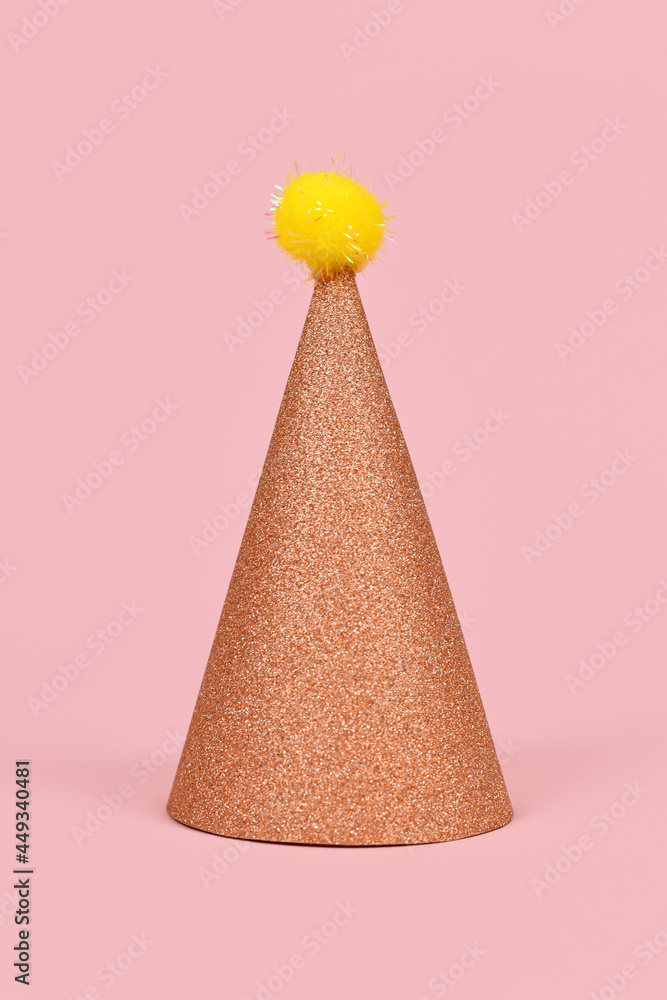 Glittering party hat on pink background Glittering party hat on pink background