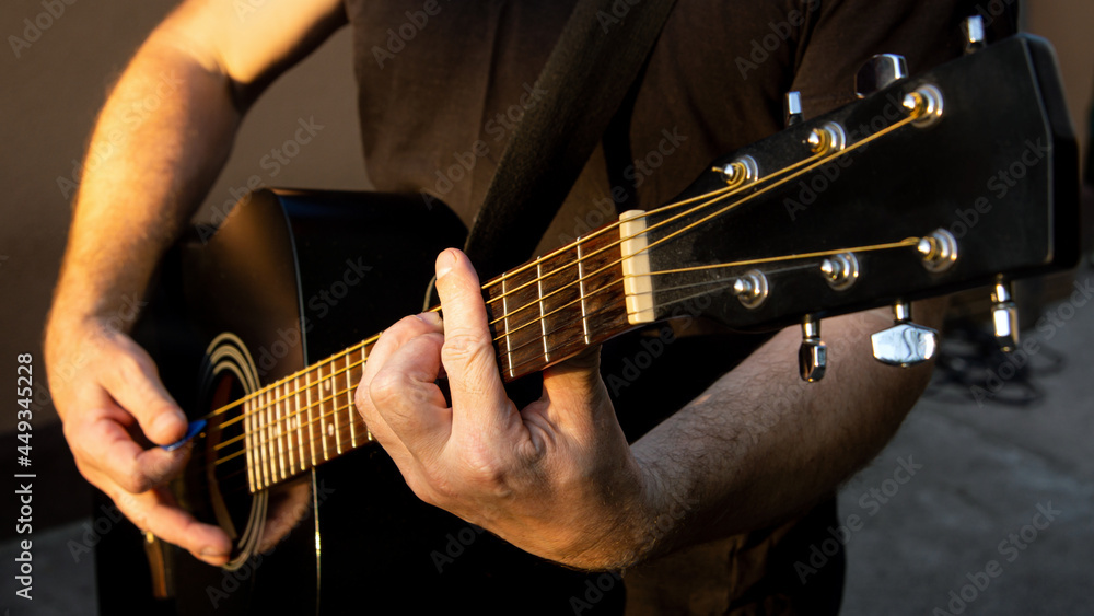 Obraz premium A man playing a melody on a guitar. Close-up