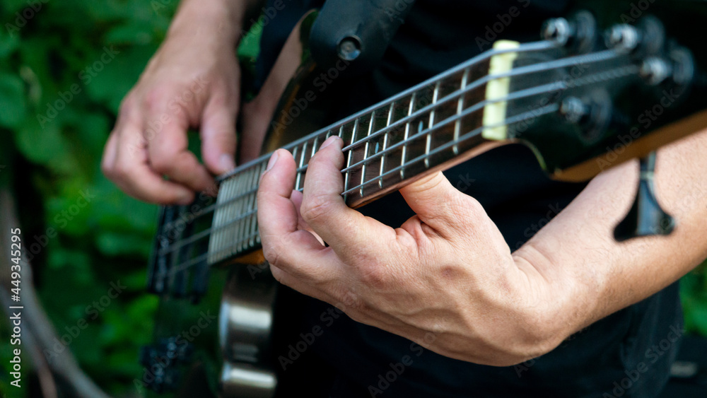 Fototapeta premium A man playing a melody on a guitar. Close-up