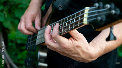A man playing a melody on a guitar. Close-up