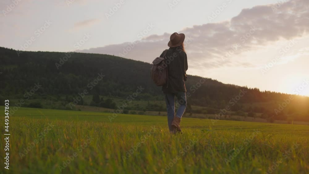 Happy tourist female with backpack walking in beautiful wild nature. Adventurous young woman on summer vacation travel journey. Mountain sunset. Happy tourist female with backpack walking in beautiful wild nature. Adventurous young woman on summer vacation travel journey. Mountain sunset.