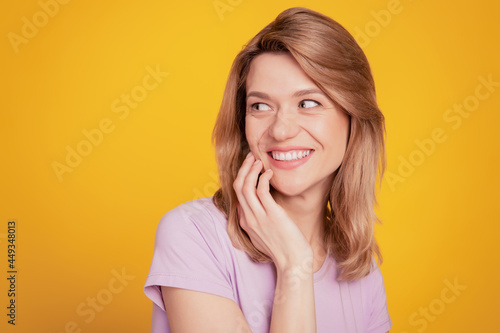 Portrait of pretty tender sweet lady look blank space posing dreamy smile on yellow background