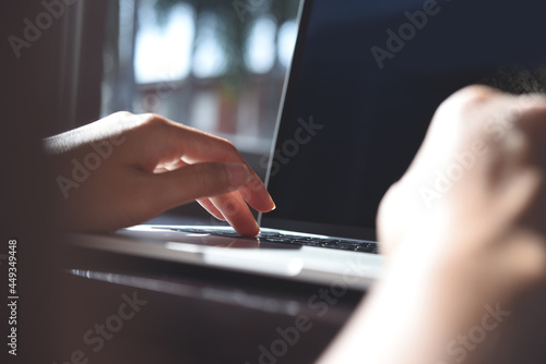 Business woman's hands working and typing on laptop computer keyboard, close up