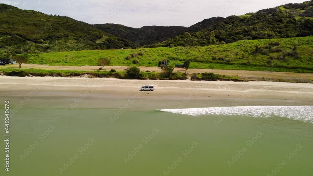 Drone aerial of van driving on sandy beach at New Zealand coast. Ahipara, Shipwreck Bay Drone aerial of van driving on sandy beach at New Zealand coast. Ahipara, Shipwreck Bay