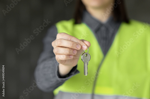 woman engineer in a white helmet and safety vest, the engineer on the construction site makes measurements and discusses the work plan, a competent engineer and designer on the premises of the