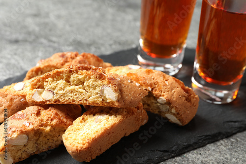 Tasty cantucci and glasses of liqueur on grey table, closeup. Traditional Italian almond biscuits photo