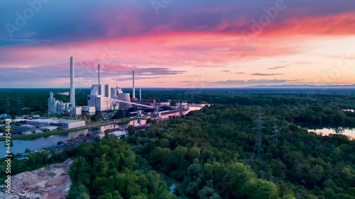 a coal-fired power station located on a river next to a domestic port, during a colourful sunset. timelapse sunset drone photo