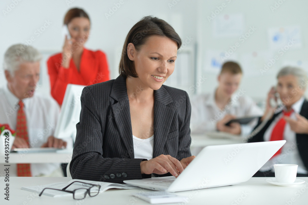 Portrait of a young woman with a laptop in office Portrait of a young woman with a laptop in office