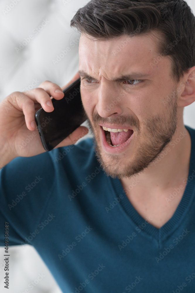 handsome young man shouting on smartphone handsome young man shouting on smartphone
