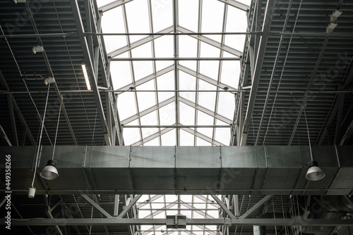 Metal structure of roof shopping center, indoors. Built-in windows at the top for illumination. Architecture of large industrial building