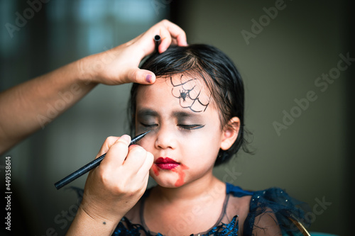 Mother Painting Daughters Face. Halloween Party.
