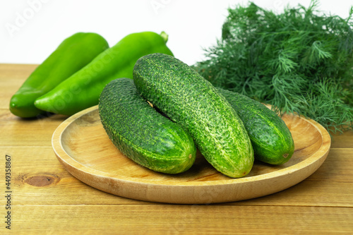 Fresh cucumbers, long sweet pepper and dill on wooden table. Green vitamin vegetables. Healthy food.