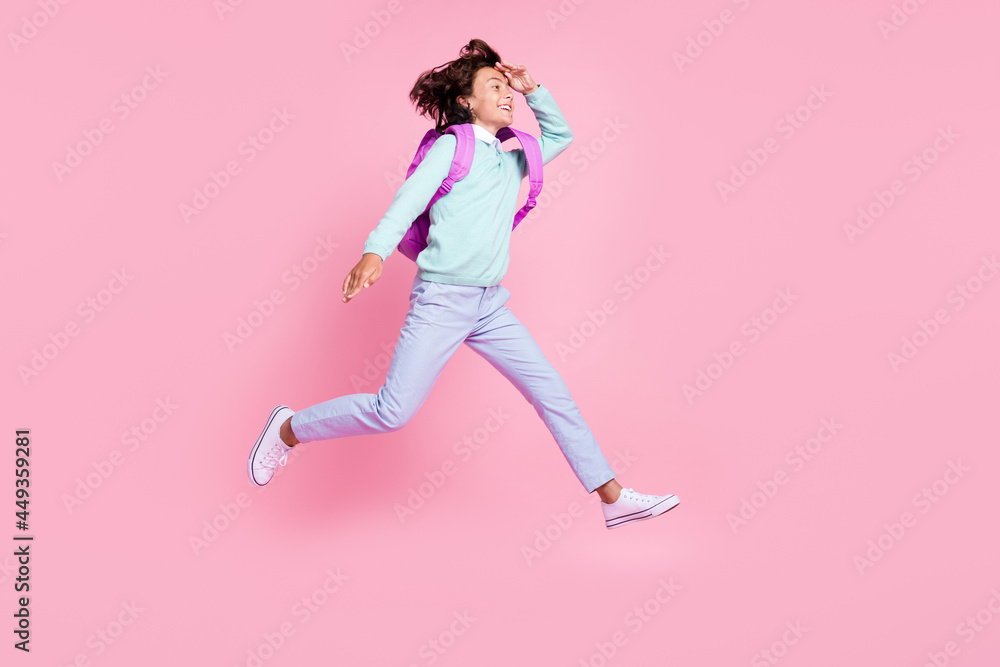 Profile photo of adventurous boy jump watch see empty space wear bag teal shirt isolated pink color background