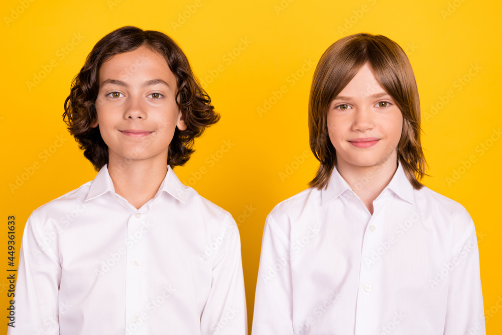 Photo of two cheerful positive classmates schoolboys look camera wear white shirt isolated yellow color background Photo of two cheerful positive classmates schoolboys look camera wear white shirt isolated yellow color background