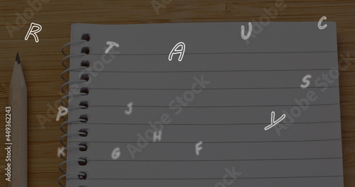 Image of letters changing over ruled notebook and pencil