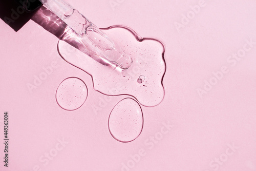 Hyaluronic acid with a dropper on a pink background. Side view.