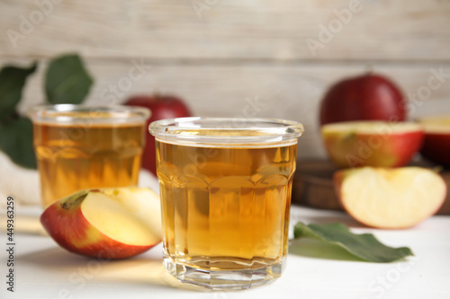 Glass of delicious apple cider on white table. Space for text