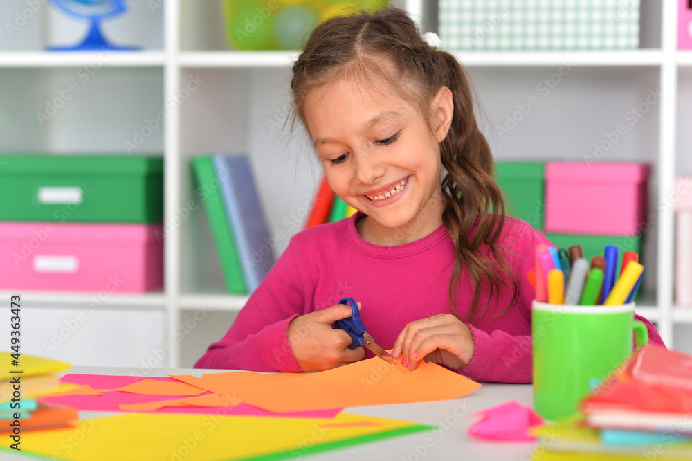Porait of cute little girl is cutting paper Porait of cute little girl is cutting paper