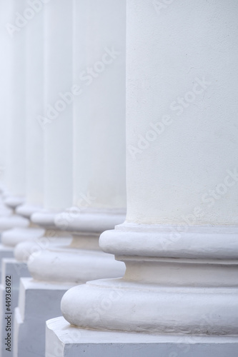 The base of the white ancient stone columns standing in a row. Selective focus. Abstract architectural background.